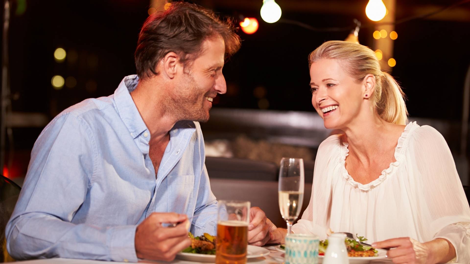 Un hombre y una mujer disfrutan de una cena juntos en un restaurante elegante.