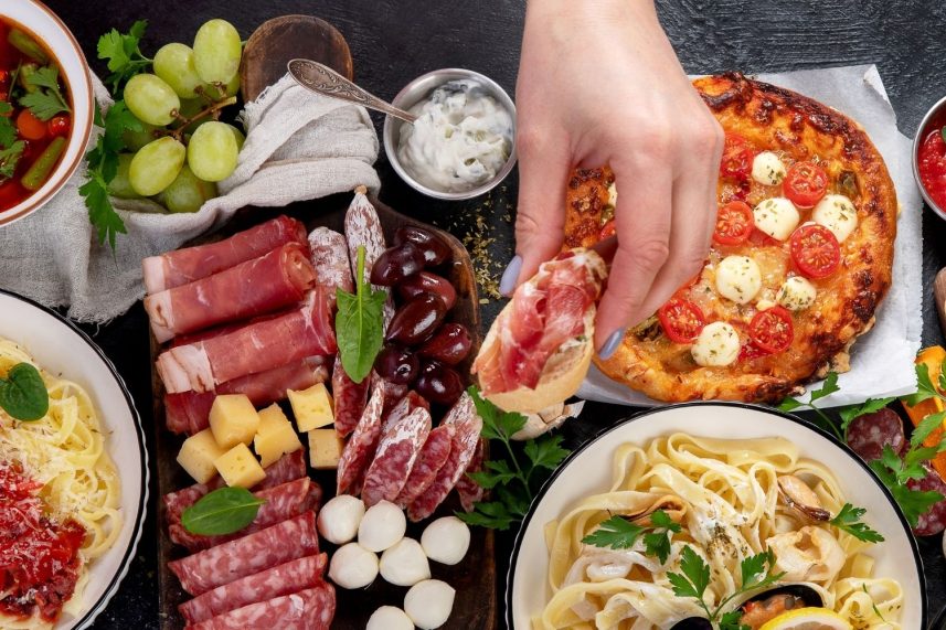 Persona sosteniendo un plato de comida, destacando la presentación y los colores vibrantes de los alimentos.