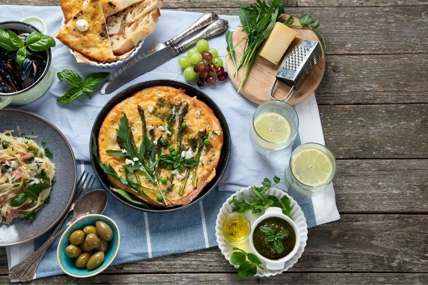Mesa con una selección de comidas y bebidas, lista para una reunión o celebración.
