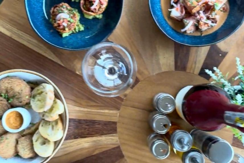 Mesa con platos de comida y bebidas dispuestos de manera atractiva.