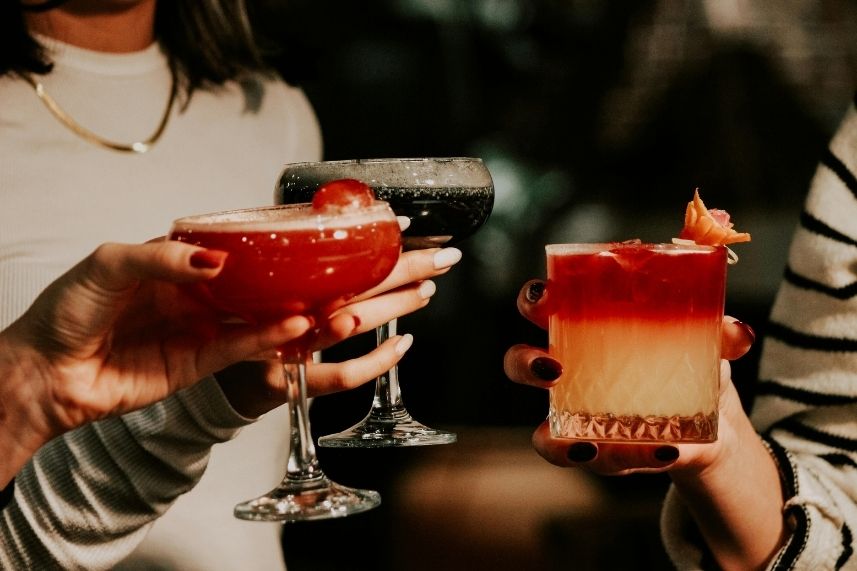 Visitante disfrutande sus cocteles en una noche agradable.