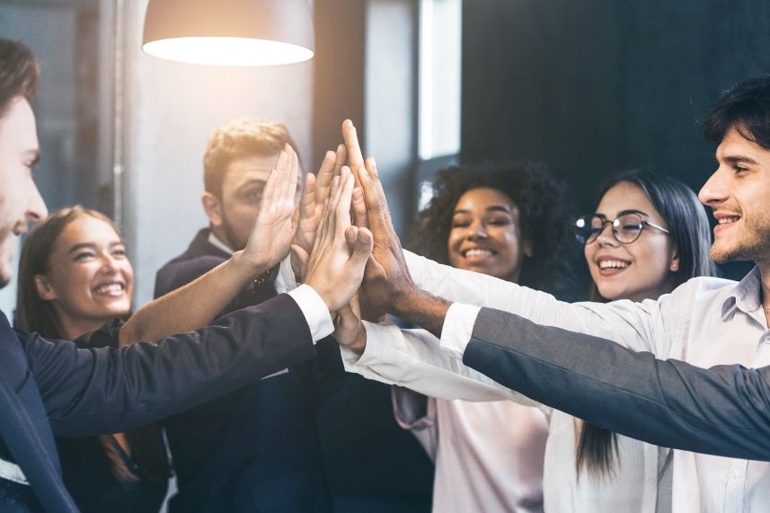 Compañeros de oficina en señal de celebración y camaradería.