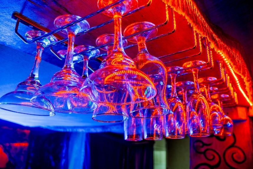 Copas de vino alineadas en una barra, creando un ambiente acogedor y sofisticado.